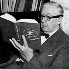 E.V. McCollum reading a hardcover copy of A History of Biochemistry