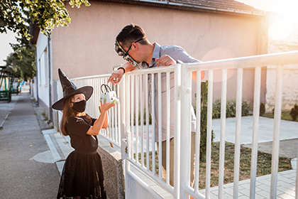 Little girl trick or treating dressed as a witch