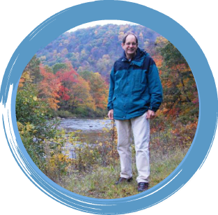 Smiling man, standing outdoors in front of bay