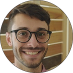 young man wearing glasses smiling for the camera