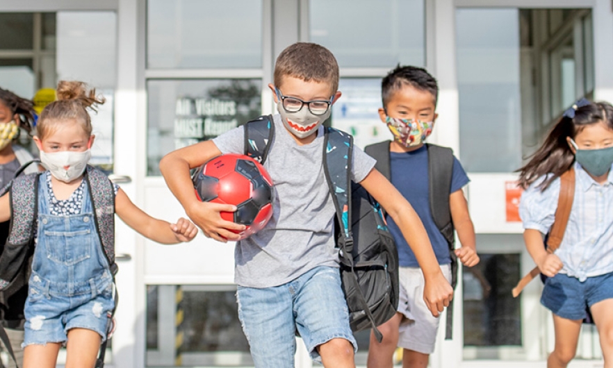 Children at school playing in masks