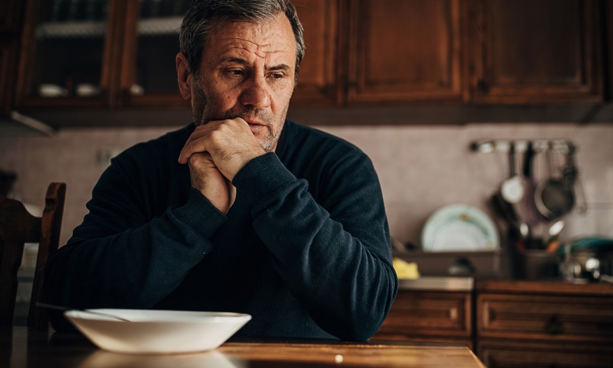 Man thinking at kitchen table