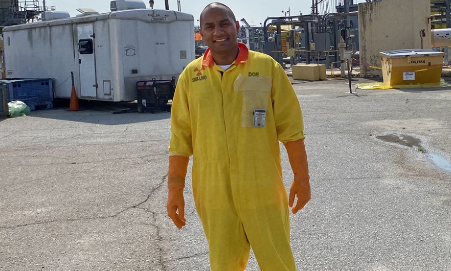 Young male on paved worksite in yellow safety suit