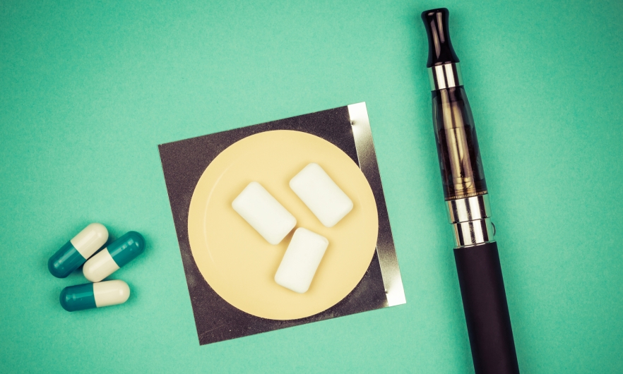 An image of smoking cessation aids, including gum, pills and an e-cigarette.