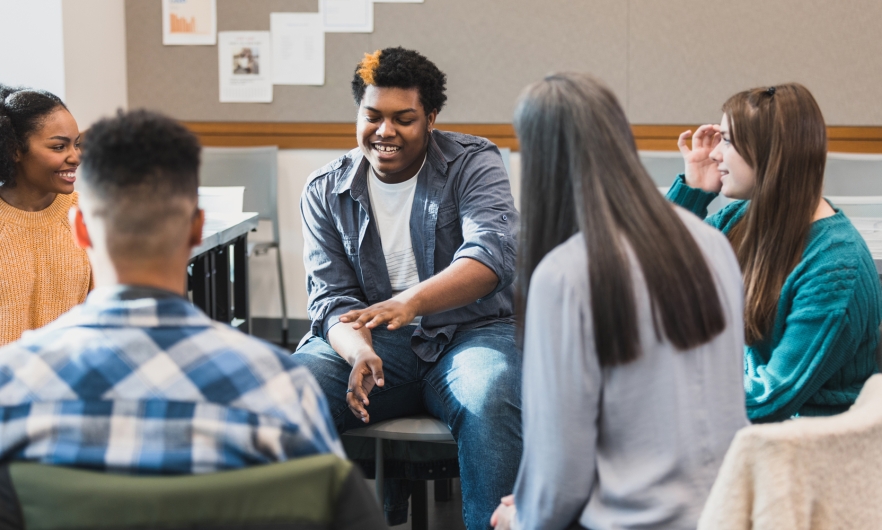 Teenagers at school gathered in a circle talking