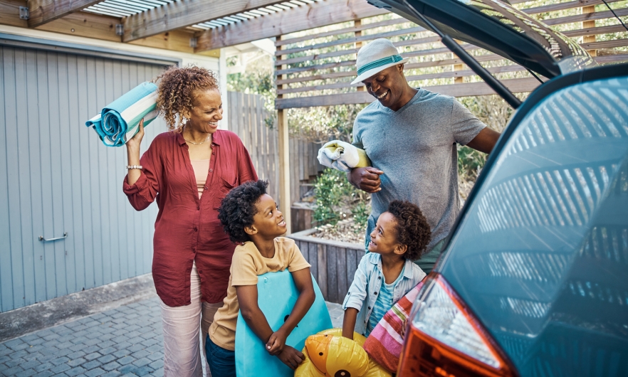 A family packs their car for summer vacation.