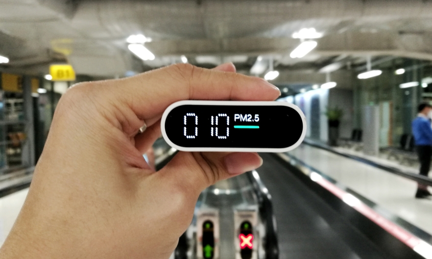 A hand holding an air quality monitor.