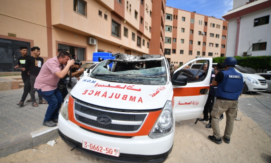 Members of the press take photographs of a damaged ambulance in an Israeli army attack as clashes between Palestinian factions and Israeli forces continue in Khan Yunis, Gaza on October 07, 2023. The paramedics inside the unusable ambulance were seriously injured.