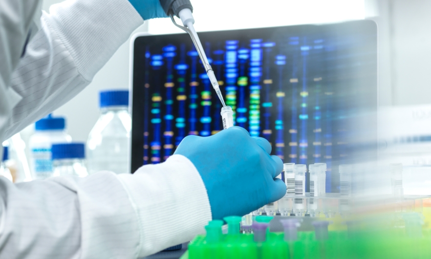 A scientist pipetting a sample into a vial for DNA testing.