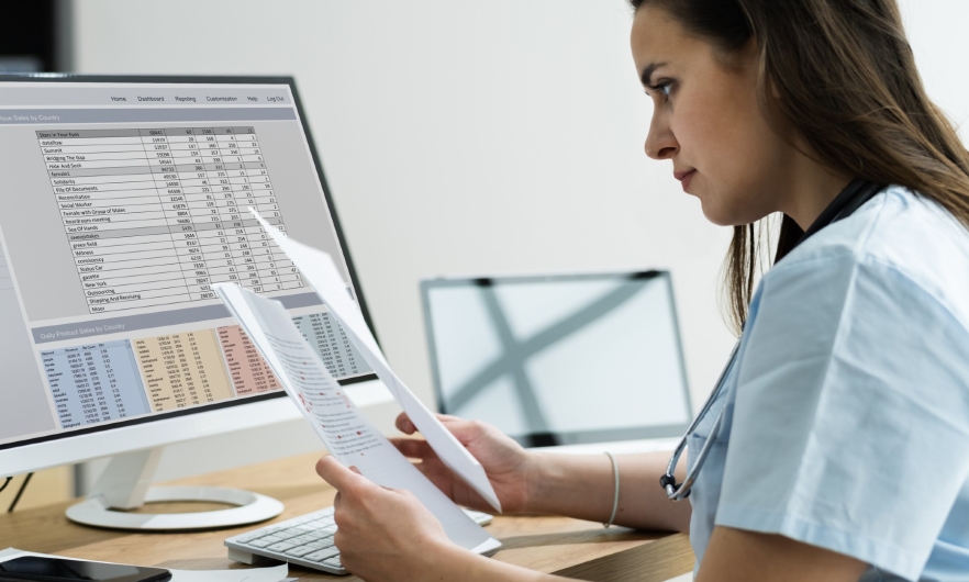 woman at computer with bills