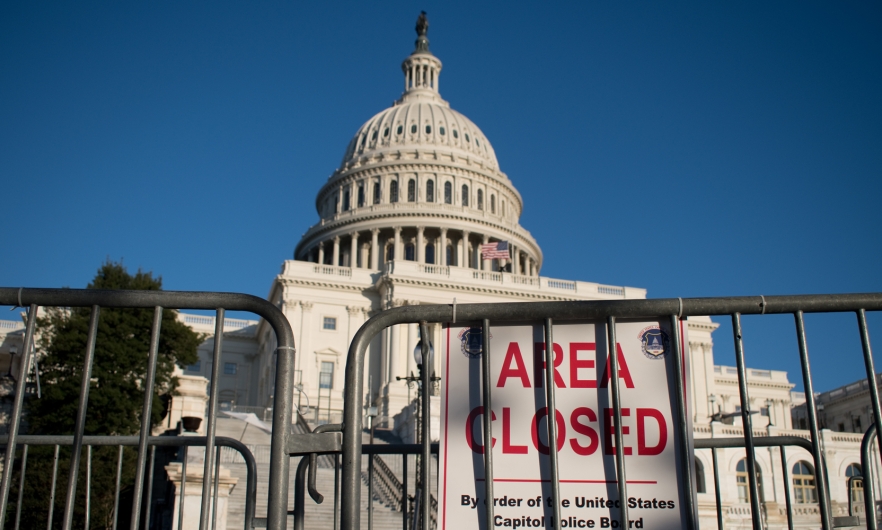 Gates surrounding the United States Capital building with a sign that reads area closed