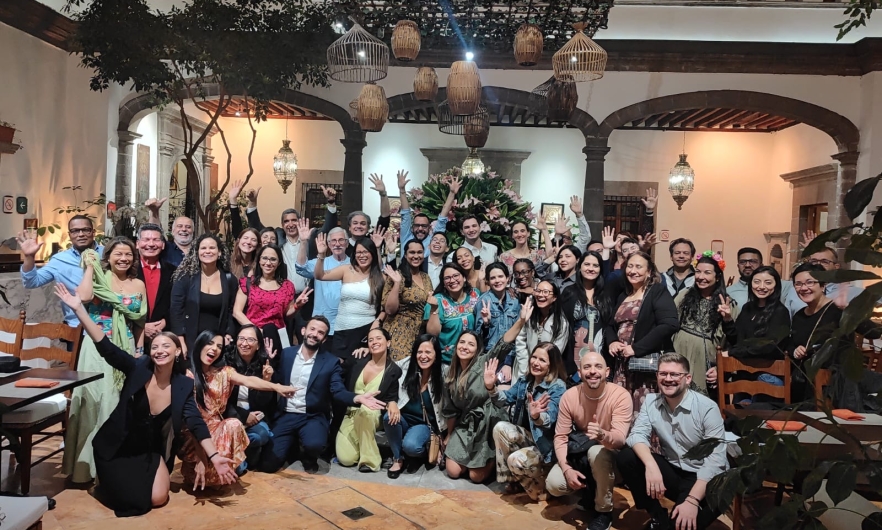 A large group of people posed for a photo in a hotel lobby