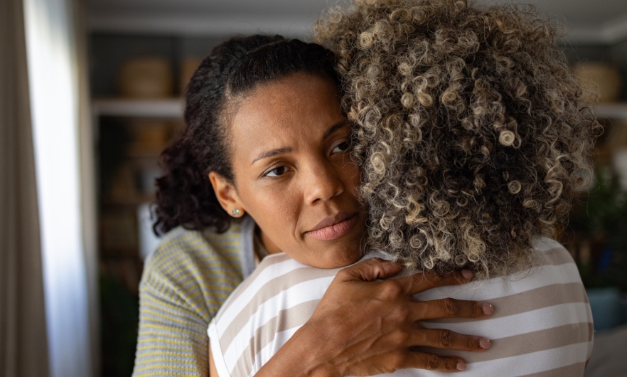 person hugs their friend to console them