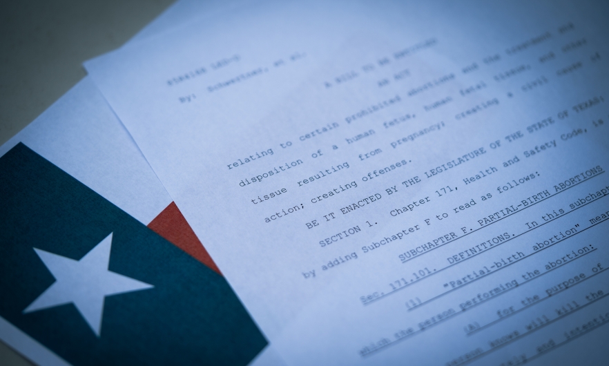 A document with a policy written and the Texas state flag in the background