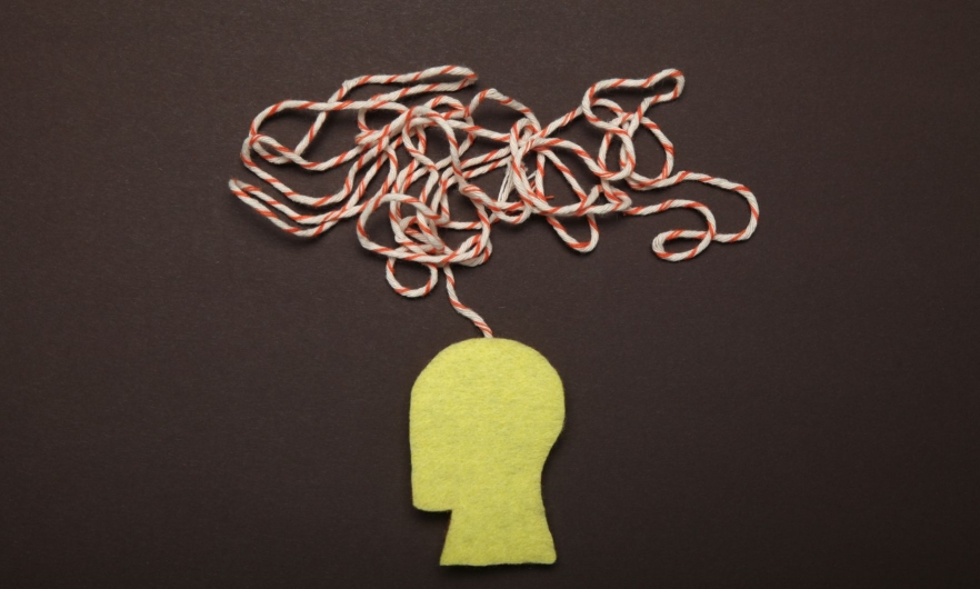 A yellow silhouette of a human head with a jumble of red and white string coming out of the stop