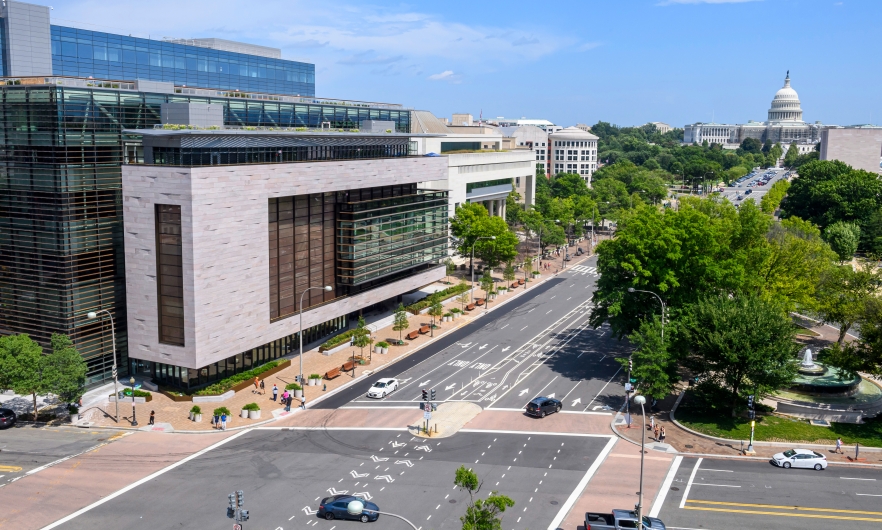 Aerial view of Hopkins Bloomberg Center in Washington, DC and the surrounding road way, pedestrian walkway, and landscaping. 
