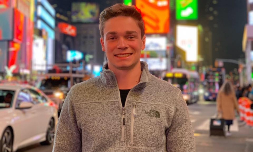 Young man standing outside on busy street