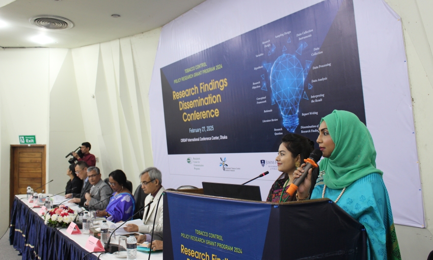 Two Bangladeshi women speak in front of a research conference
