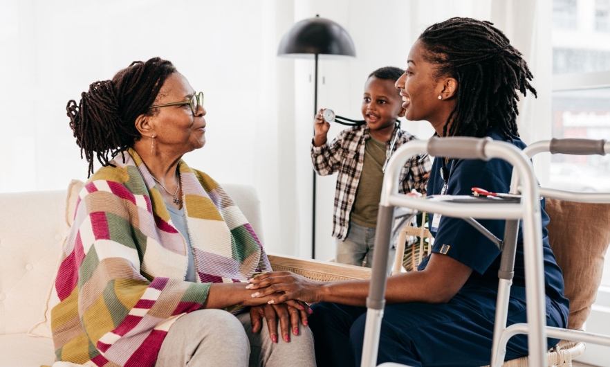 A nurse smiles at an elderly woman.