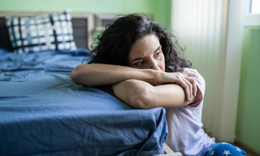 image of white woman leaning against bed