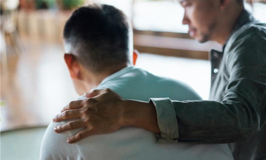 man comforts another man