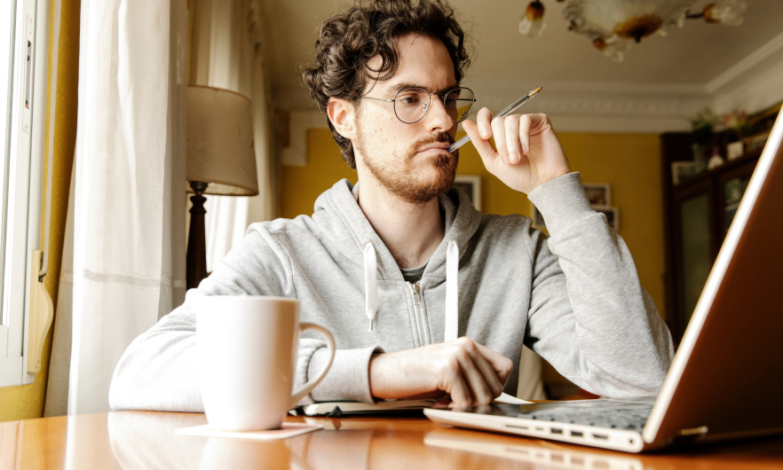 Person at home reading intently from laptop.