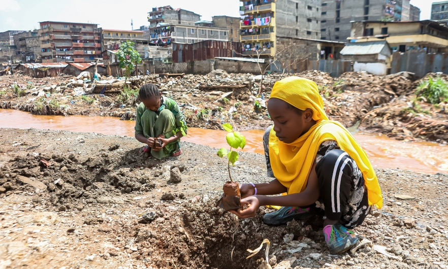 Local teenage girls resident of Kiamako slum take part in planting a tree near a site of homes destroyed by floods along the bank of Mathare river. Nairobi, Kenya, June 5, 2024. 