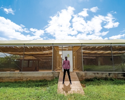 Entomologist Limonty Simubali stands in front of the “mosquito house” in Macha, Zambia, on March 30, 2022.