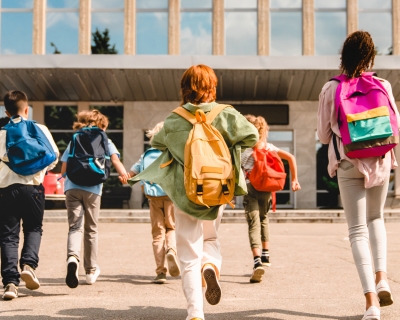 Students eagerly run towards their school to start class