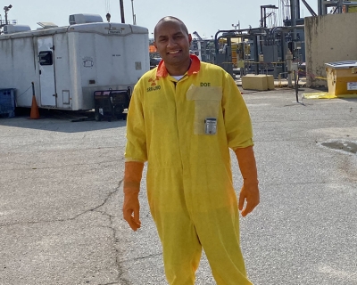 Young male on paved worksite in yellow safety suit