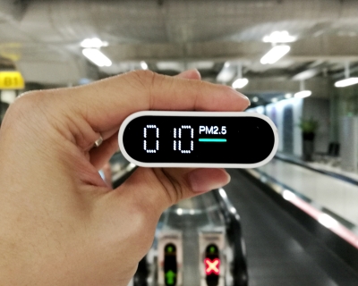 A hand holding an air quality monitor.