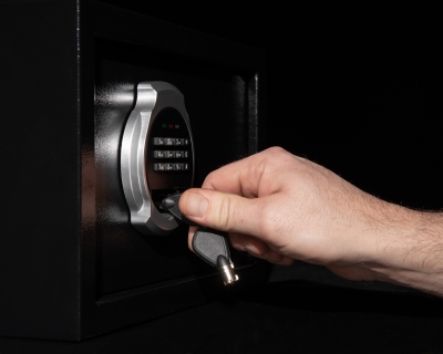 A man's hand closes a safe