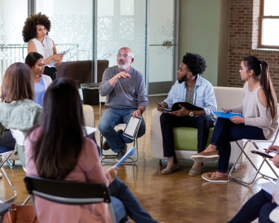 group of adults sitting in a circle talking