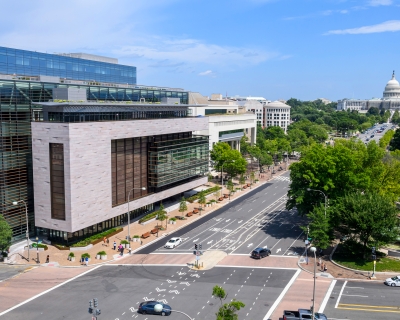 Aerial view of Hopkins Bloomberg Center in Washington, DC and the surrounding road way, pedestrian walkway, and landscaping. 