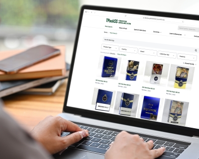 A woman wearing a hijab types on her laptop with a page open displaying the TPackSS website search screen