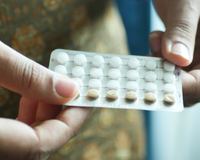 A person holding a packet of birth control pills