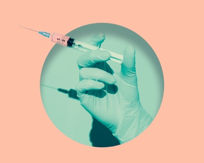 A doctor's gloved hand holding vaccine syringe placed inside a round hole of teal, background is salmon pink