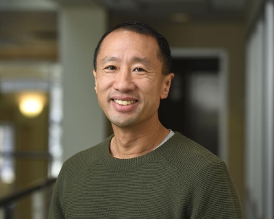 Headshot of Frank Lin, smiling in a dark green shirt.