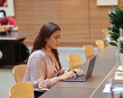 Student working at a laptop in the Bloomberg School reading room 