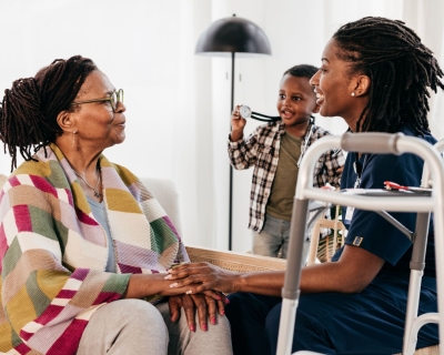 A nurse smiles at an elderly woman.