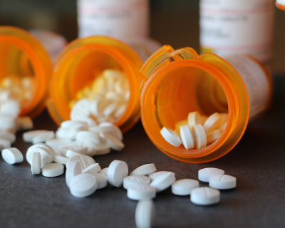 Three open bottles of prescription medications side by side.