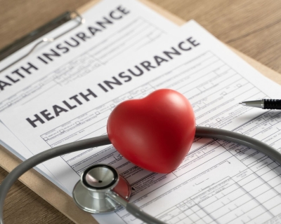 A stethoscope placed on top of a health insurance form