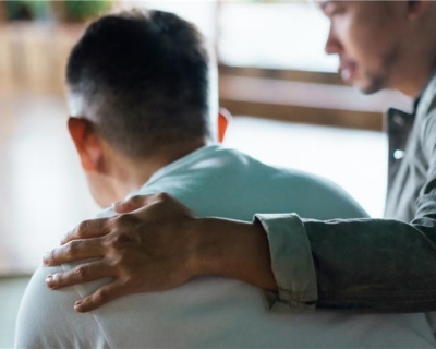 man comforts another man