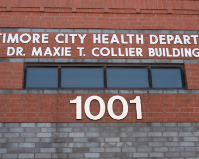 A brick building with white letters that read Baltimore City Health Department