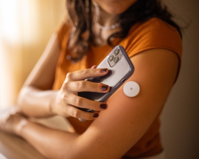 woman with iPhone and glucose monitor