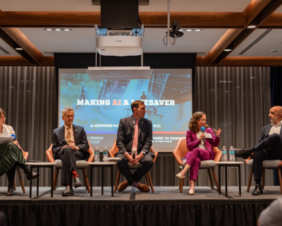 Biostatistician Elizabeth Stuart (in purple) makes a point to HHS assistant secretary Micky Tripathi; other AI event panelists (l to r): Alison Snyder, John Auerbach, and Jesse Ehrenfeld. 