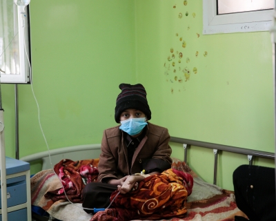 A boy who has cancer, sits on a bed as he receives treatment at the Oncology Centre in Sanaa, Yemen.