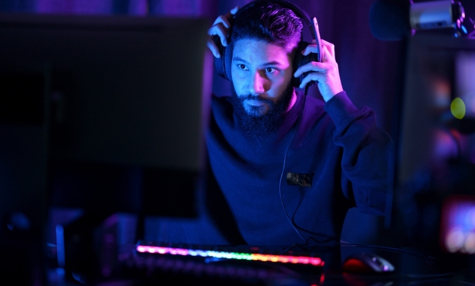 Man sitting at computer puts on gaming headset