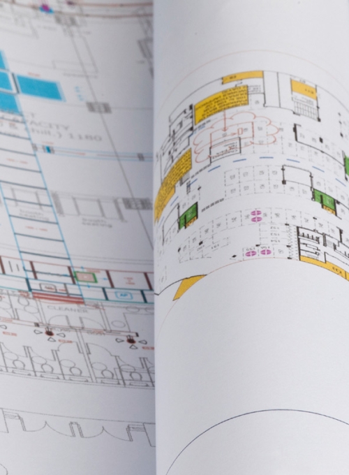 Image of a stack and roll of architectural blueprints and floorplans