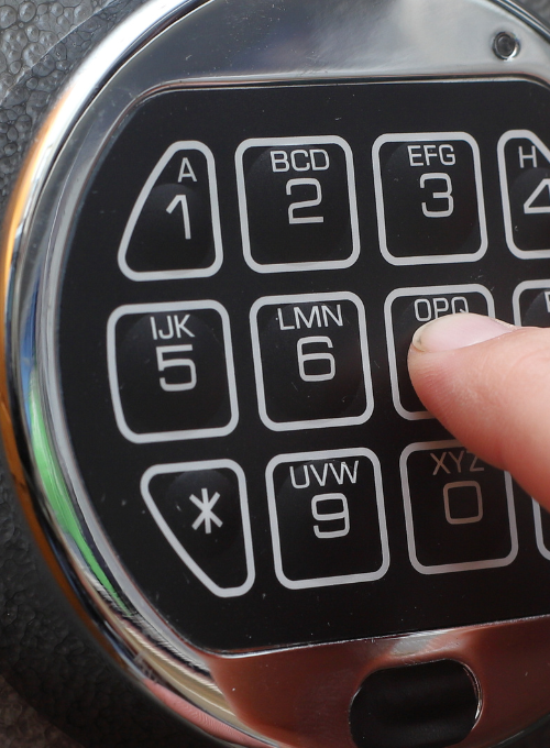 Finger pressing buttons on a safe